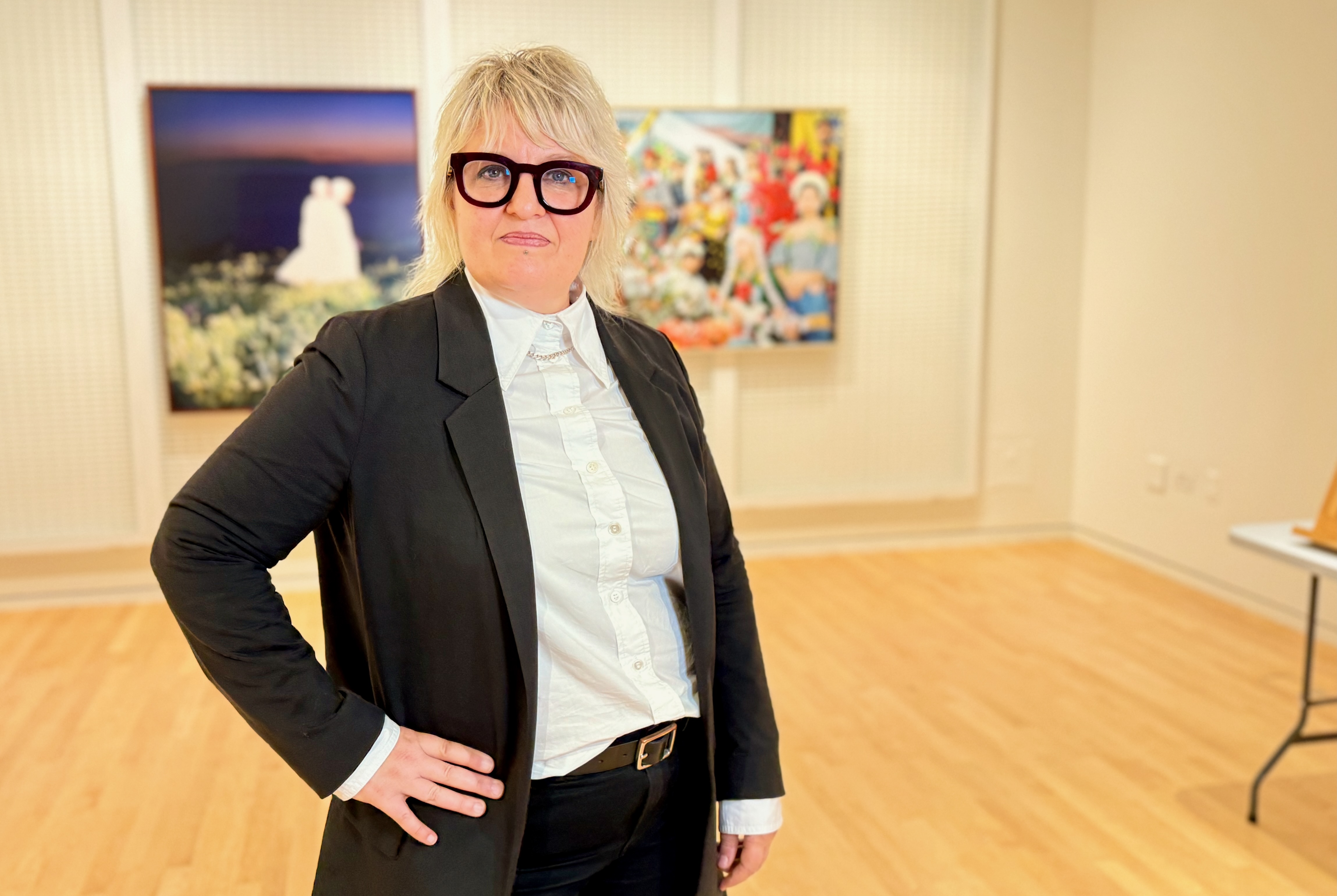 Kyle Stephan stands in front of two works of art hanging in The Block Museum's dedicated art object teaching classroom
