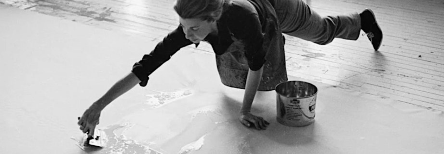 black and white photo of a white woman making art on the ground