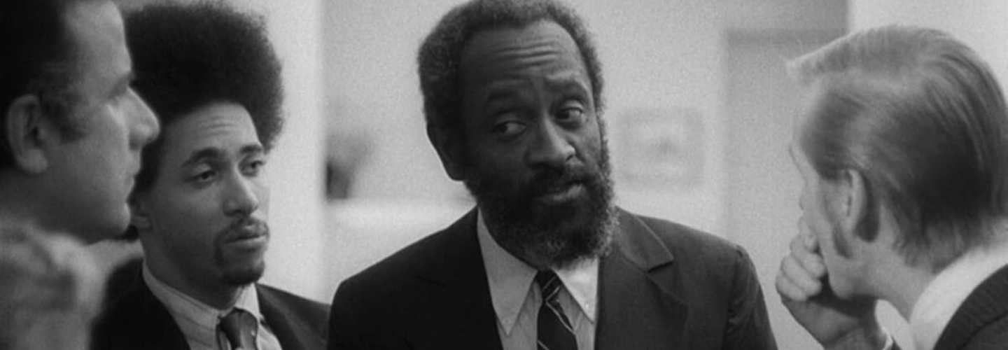 B&W image of two African-American men in suits talking to a white man