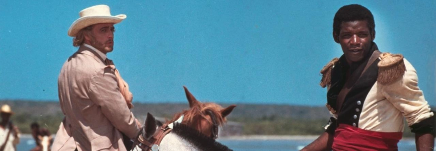 Two men on horseback in historical dress before a great blue sky