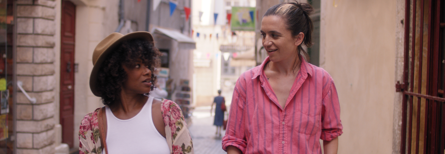 Image of two young women smiling while walking a cobblestone street