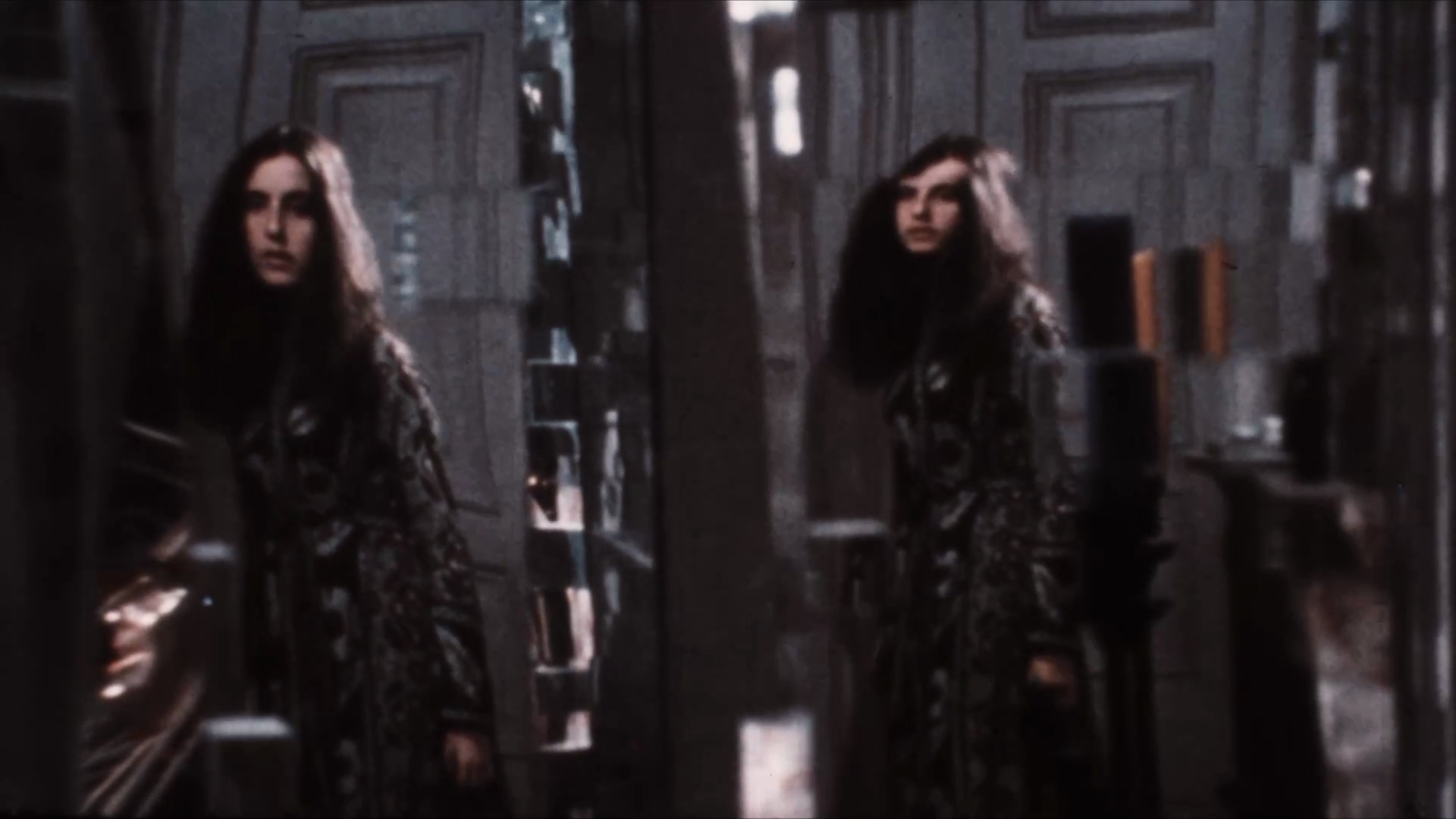 A doubled reflection of a young woman in her apartment