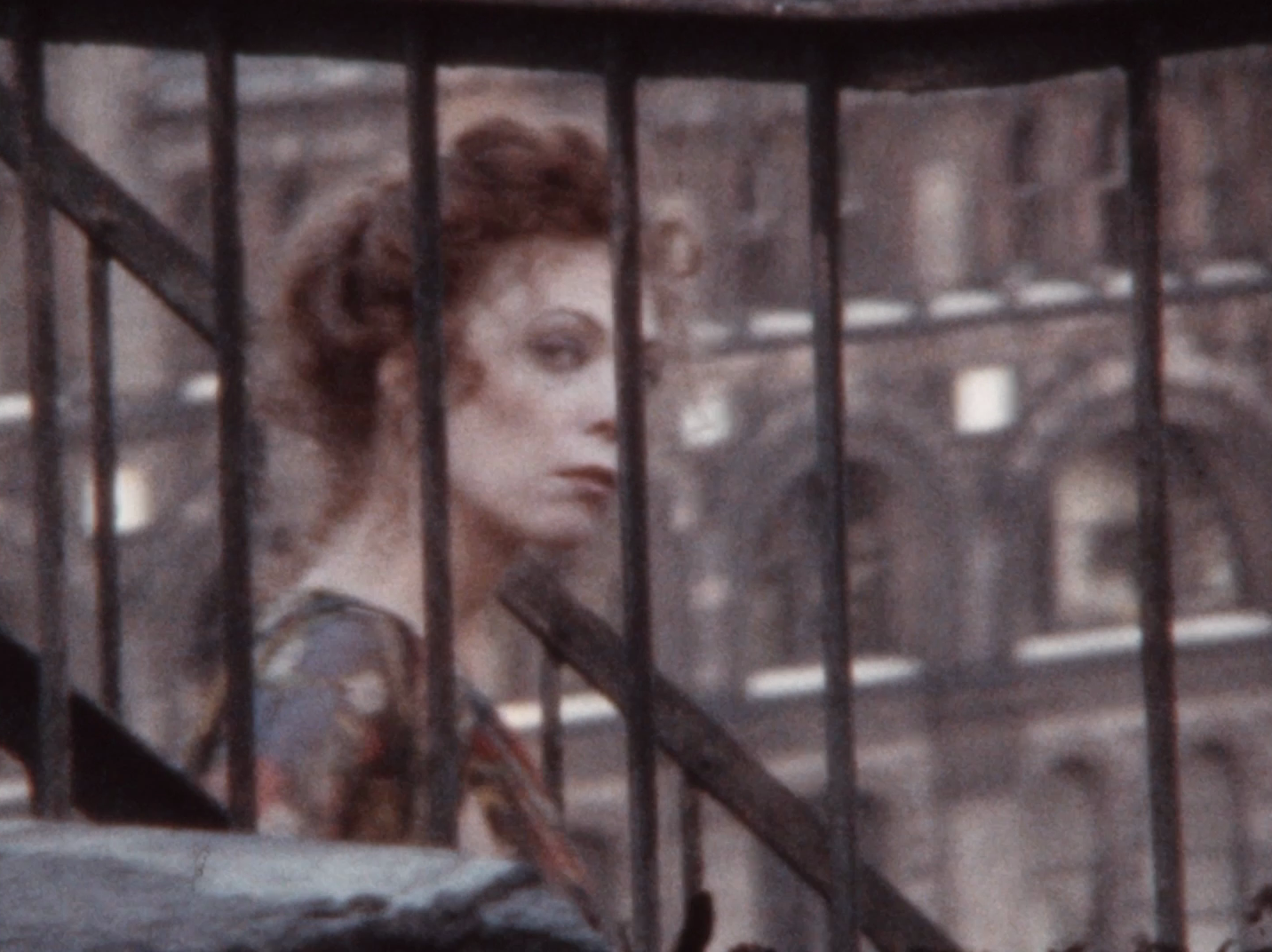 A woman in a dress standing in front of an apartment building