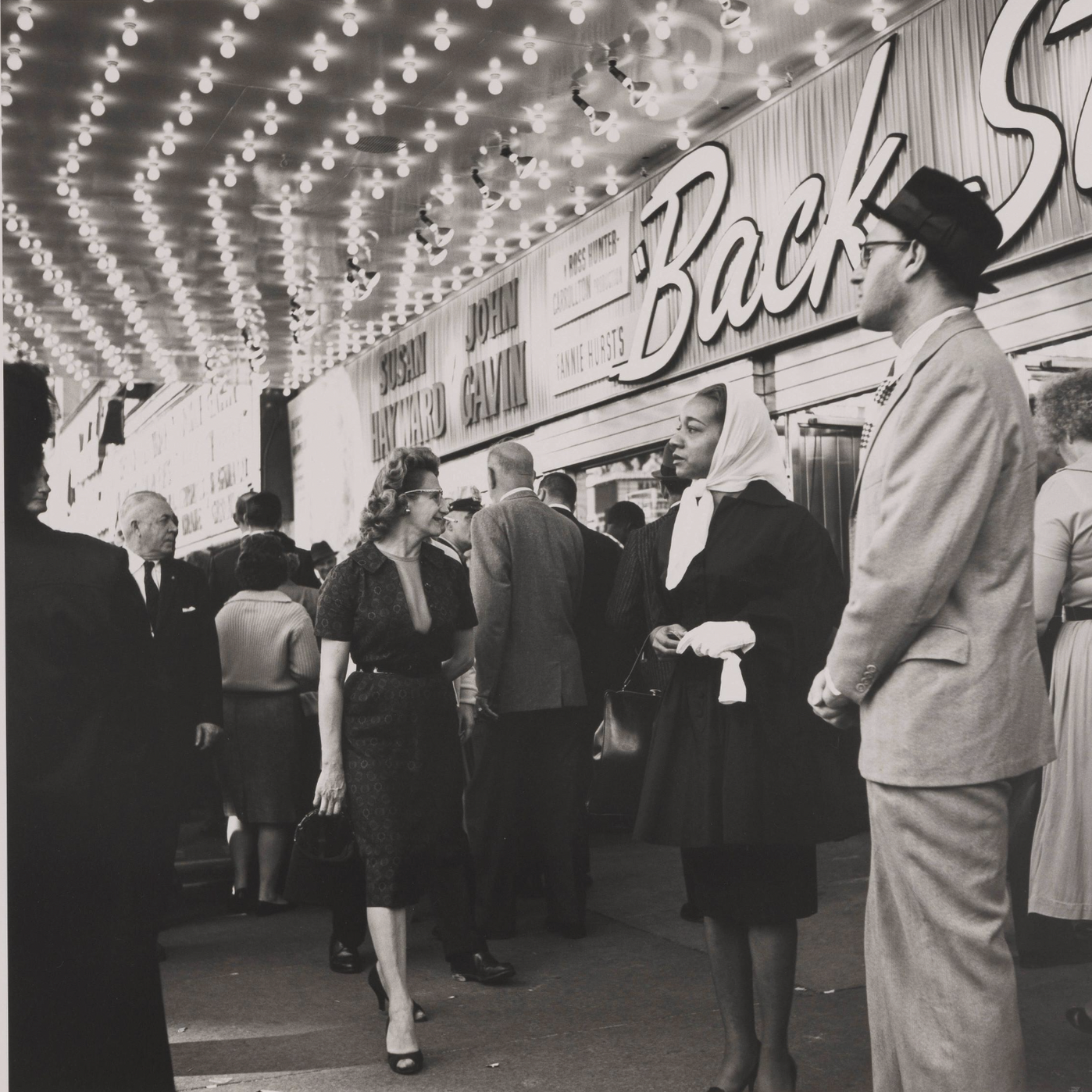 black and white photo of people standing in front of theater